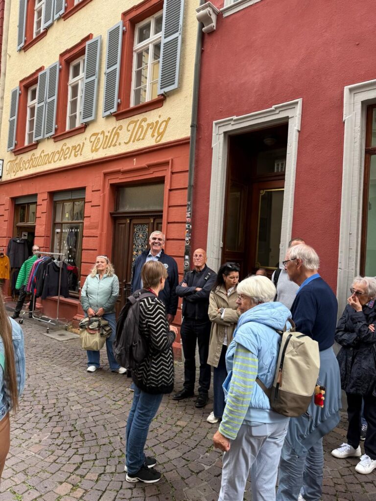 Gruppenmitglieder bei einer Stadtführung in Heidelberg vor historischen Fassaden