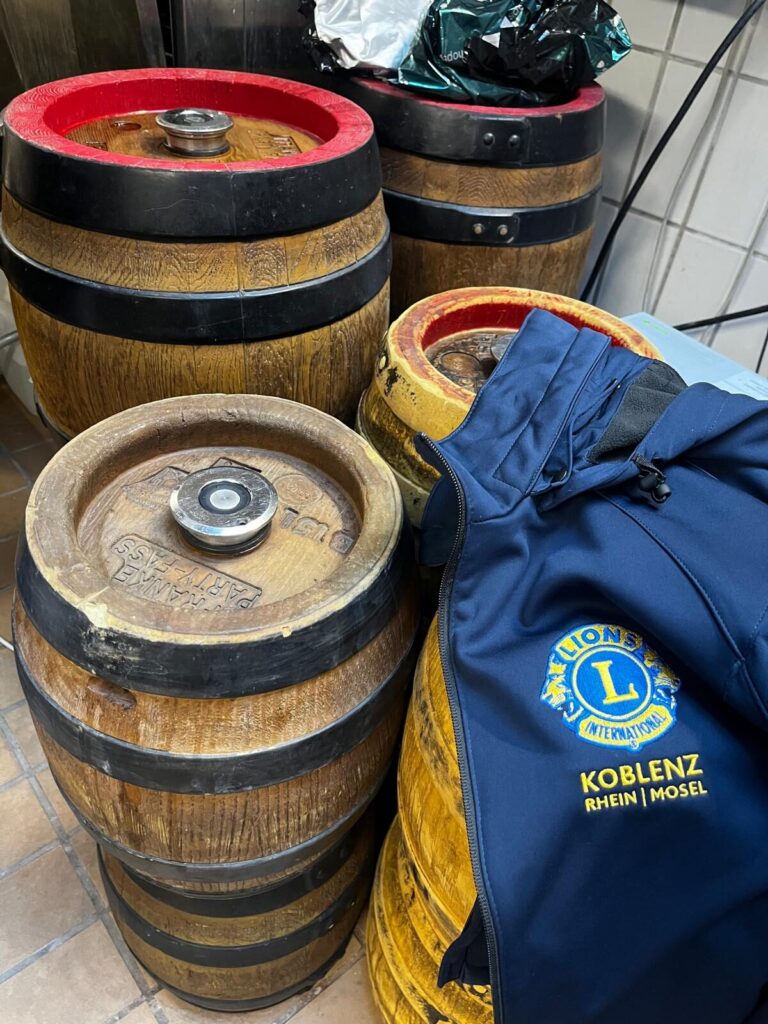 Holzfässer auf gefliesten Boden mit Lions-Jacke im Vordergrund