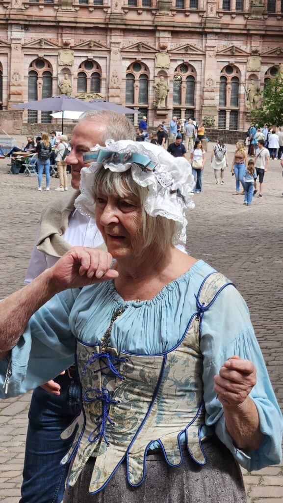 Frau in barockem Kostüm auf dem Schlossplatz vor historischer Kulisse